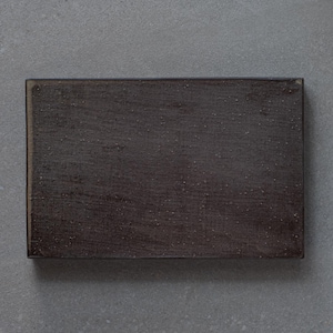 May include: A dark grey rectangular ceramic tile with a rough, textured surface.