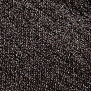May include: Close-up of a dark brown knitted fabric with a textured surface.
