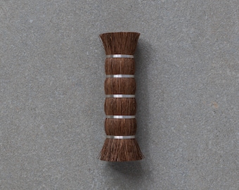 May include: A brown brush with a wooden handle and silver metal bands. The brush is made of natural bristles and is designed for cleaning.