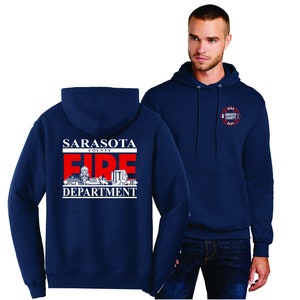 Puede incluir: Una sudadera con capucha azul marino con un gráfico blanco y rojo en la parte posterior que dice "Sarasota County Fire Department" y un gráfico blanco y rojo más pequeño en la parte delantera que dice "Fire Sarasota County Dept."