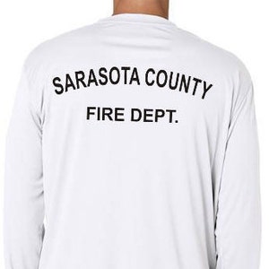 Puede incluir: Camiseta blanca de manga larga con texto negro en la espalda que dice "Sarasota County Fire Dept."