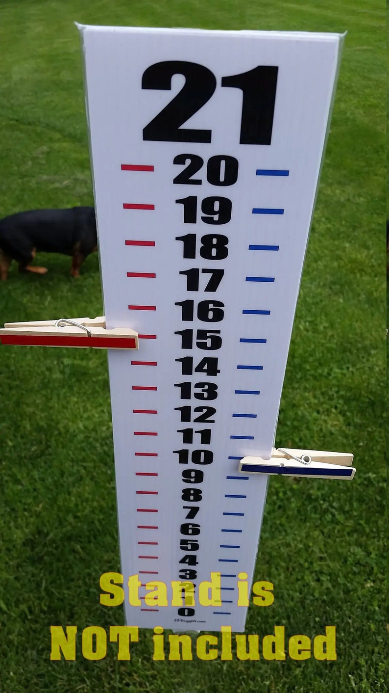 May include: A white vertical height chart featuring black numbers from 0 to 21, with red tick marks on the left and blue tick marks on the right. Two wooden clothespins, one red and one blue, are clipped to the chart. Text reads: Stand is NOT included.