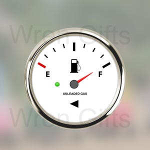 May include: A white fuel gauge with a black needle pointing to the full mark. The gauge has a silver bezel and a black background with the text "UNLEADED GAS".