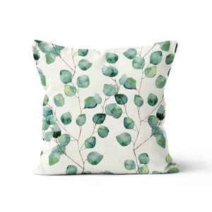 May include: A white pillow with a green watercolor eucalyptus leaf pattern.