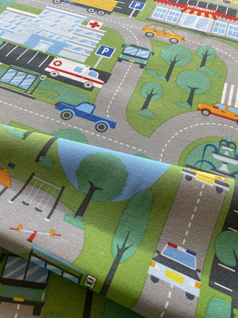 May include: A colourful play mat with a city theme. The mat features a variety of vehicles, including cars, trucks, buses, and an ambulance. There are also trees, buildings, and a park with a swing set. The mat is made of a soft, durable fabric and is perfect for children to play on.