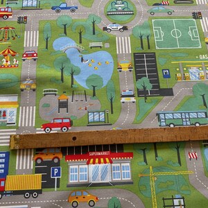 May include: A colourful play mat with a city theme. The mat features roads, buildings, cars, a park, a football pitch, a petrol station, and a supermarket. The mat is made of a soft, durable material and is perfect for children to play on.