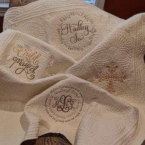 May include: A white quilted blanket with embroidered text and a cross design. The text reads "For this child we have prayed" and "Before I formed you in the womb I knew you Hadley Jo La Bat 8lbs. 7oz. 20 inches October 6, 2022 7:46 AM".