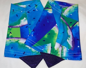 May include: A pair of blue and green arm warmers with a watermelon print. The arm warmers have a purple trim.
