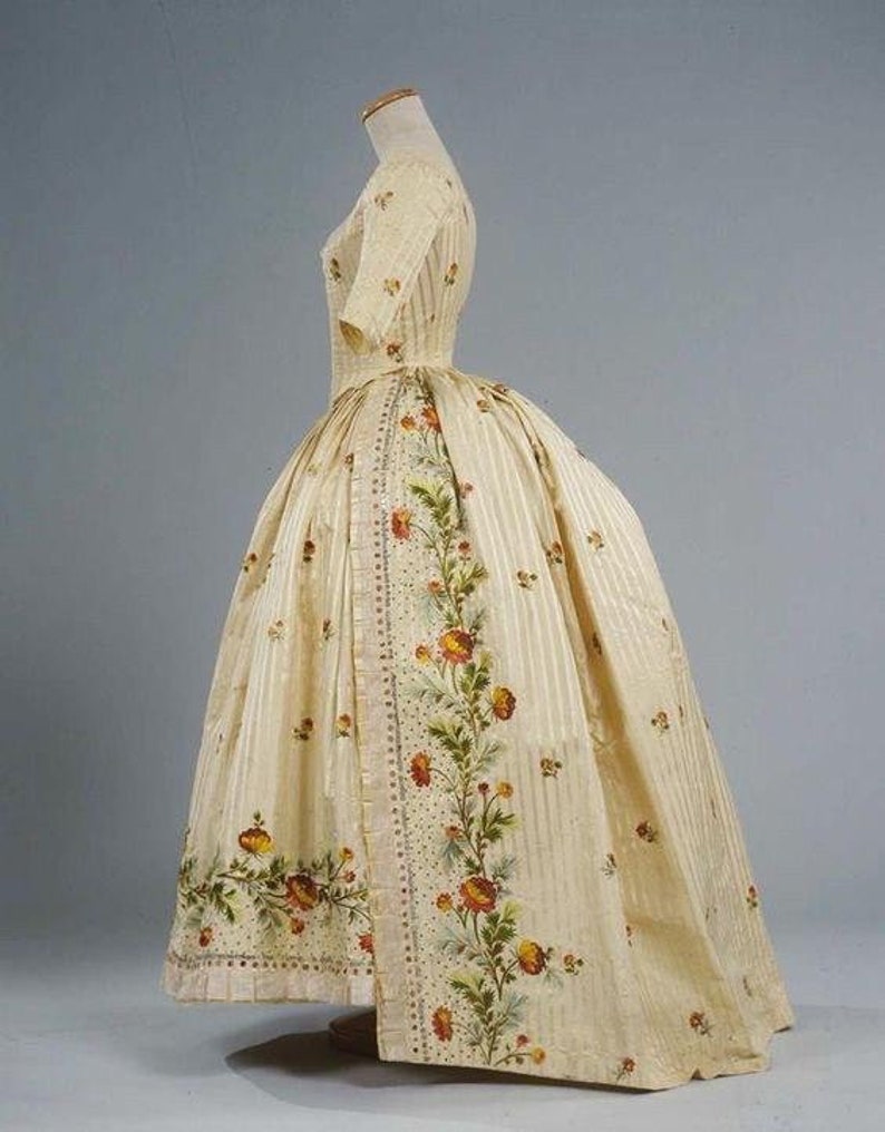 May include: A white dress with a floral print and a striped pattern. The dress has a fitted bodice and a full skirt.