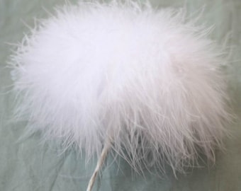 Peut inclure: Un grand boa en plumes blanches et moelleuses. Le boa est doux et plumeux, et il est parfait pour ajouter une touche d'élégance à n'importe quelle tenue.