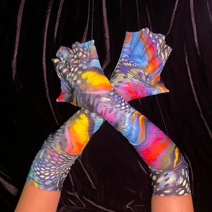 May include: A pair of colorful, long fingerless gloves with a psychedelic, abstract print. The gloves are made of a stretchy, lightweight fabric and have a unique, textured design.