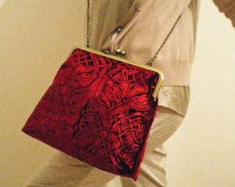 A beautiful kisslock handbag in an embossed iridescent velvet celtic design