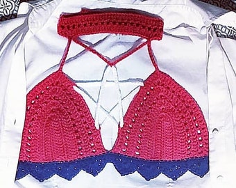May include: A summer outfit featuring a red and blue crochet top, white button-down shirt, denim shorts, and silver sandals. The shorts have the text "Industrial Cotton". The outfit is laid out on a patterned surface.