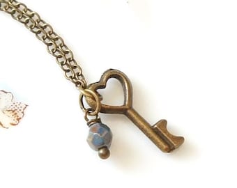 Collar con llave esqueleto de corazón de bronce pequeño, estilo antiguo, vintage y cuentas checas azul turquesa.