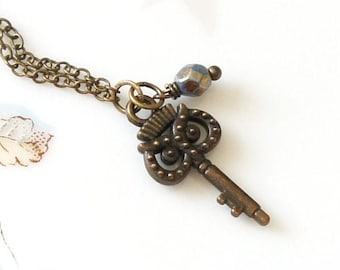 Collar con llave esqueleto de corazón de bronce pequeño, estilo antiguo, vintage y cuentas checas azul turquesa.