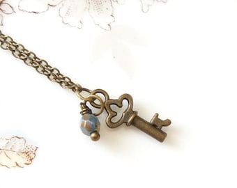 Collar con llave esqueleto de corazón de bronce pequeño, estilo antiguo, vintage y cuentas checas azul turquesa.