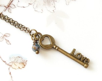 Collar con llave esqueleto de corazón de bronce pequeño, estilo antiguo, vintage y cuentas checas azul turquesa.