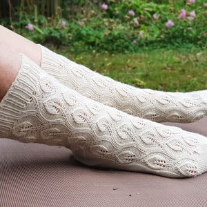 May include: A pair of white knitted socks with a delicate leaf pattern. The socks are made of a soft, breathable material and are perfect for everyday wear.