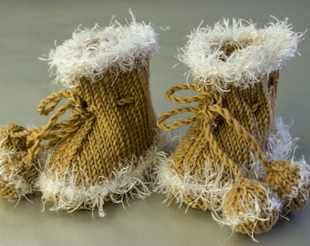 May include: A pair of knitted baby booties with white fur trim. The booties are brown and have a tie at the top.