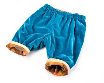 May include: Blue velvet shorts with a contrasting orange and brown plaid trim around the waistband and leg openings.