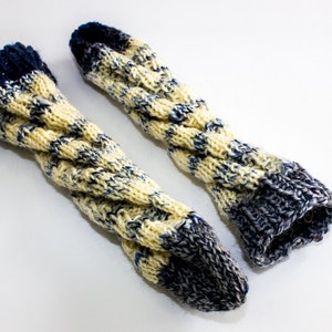 May include: A pair of knitted arm warmers with a yellow and blue color pattern. The arm warmers are made of a soft, cozy yarn and have a ribbed texture.