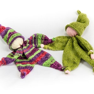 May include: Two knitted dolls, one in green and one in purple, green, and red stripes. Both dolls have a knitted hat and a white face.