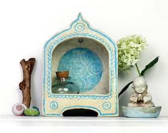 Santuario de altar con patrón azul sobre fondo beige. Pequeño altar para recuerdos preciosos.