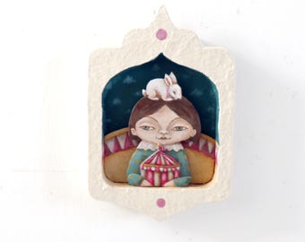 Pintura de una chica de circo con un conejo blanco, marco hecho a mano con capas.