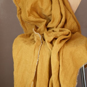 Lightweight linen throw blanket with short fringe around in mustard yellow color