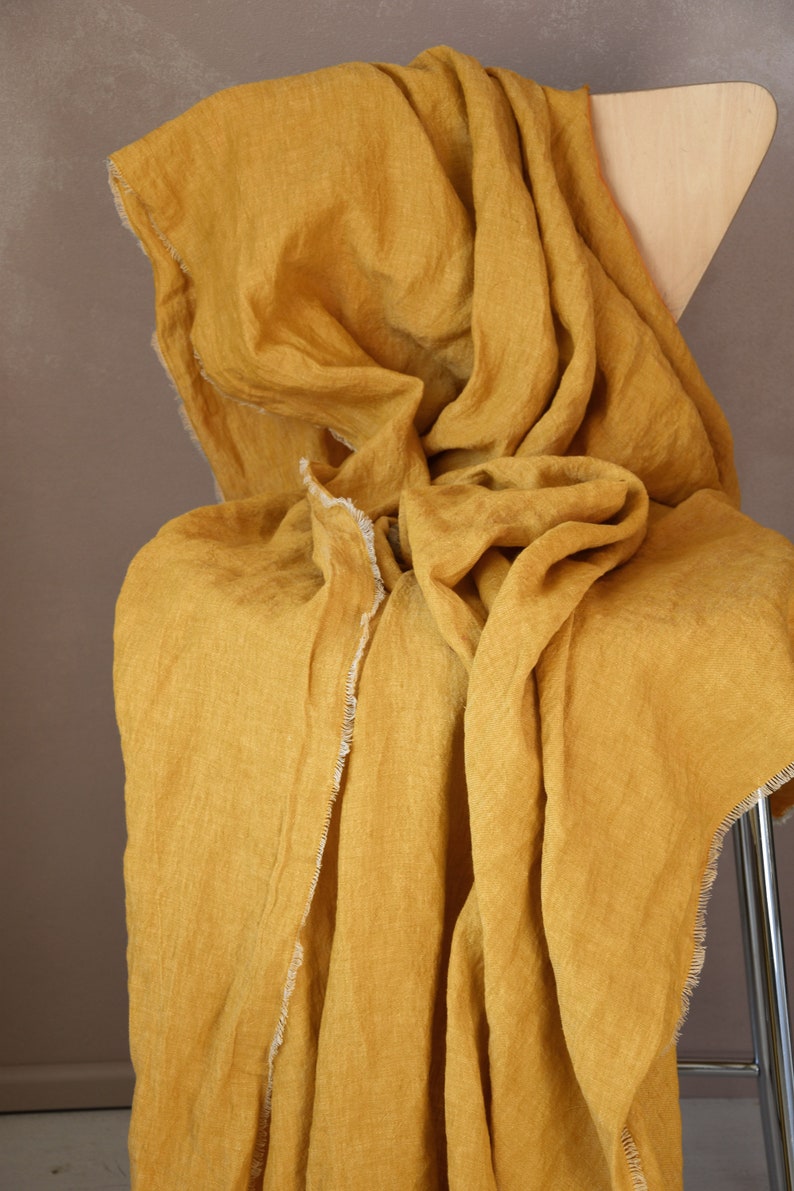 Lightweight linen throw blanket with short fringe around in mustard yellow color