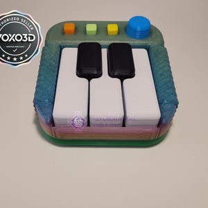 Könnte beinhalten: Eine weiße Keramik-Tasse mit schwarzem Henkel und dem Text "But First, Coffee" in fetter, schwarzer Schrift. Die Tasse steht vor einem verschwommenen Hintergrund, der eine gemütliche Umgebung suggeriert.