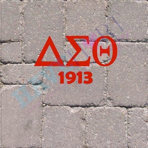 May include: Red Greek letters Delta Sigma Theta on a grey brick background with the year 1913 below.