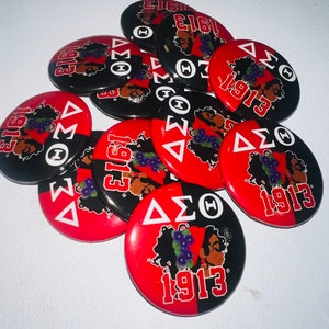 May include: A collection of round buttons with a red and black color scheme. Each button features the Greek letters Delta, Sigma, and Theta, along with the number 1913 and an illustration of a woman with flowers.