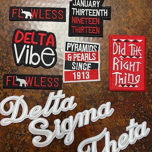 Op de afbeelding: Collectie geborduurde patches in diverse vormen en maten. Ontwerpen omvatten de woorden "FLAWLESS", "DELTA VIBE", "PYRAMIDS & PEARLS SINCE 1913", "Did The Right Thing" en "Delta Sigma Theta".