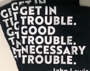 May include: A black t-shirt with white text that reads "Get in good trouble. Necessary trouble." - John Lewis.
