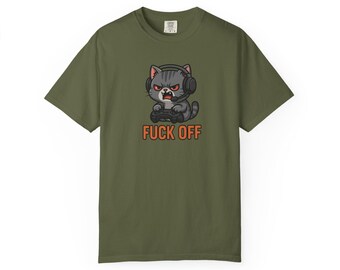 May include: Olive green t-shirt featuring a cartoon cat wearing headphones and holding a game controller. The cat has an angry expression. The text "FUCK OFF" is printed in orange below the cat.
