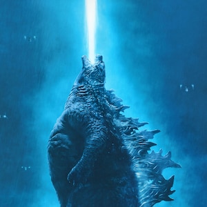Può includere: Un grande mostro rettile blu con una schiena spinosa e una bocca blu incandescente, ruggente su uno sfondo blu.