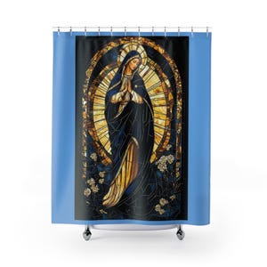 Puede incluir: Cortina de ducha con una representación estilo vidriera de una figura religiosa con una túnica azul oscuro y las manos juntas en oración. La figura está rodeada por un halo dorado y detalles florales, sobre un fondo negro.