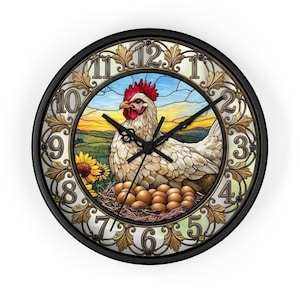 May include: A round wall clock with a black frame featuring a central illustration of a white chicken sitting on a nest of brown eggs. The background depicts a landscape with sunflowers and a sunset. The clock face has gold-toned ornate numerals.