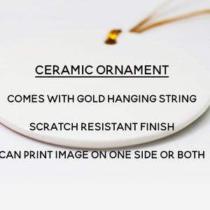 Puede incluir: Un adorno ovalado de cer&aacute;mica blanca con un cord&oacute;n dorado para colgar. El texto en el adorno dice: CERAMIC ORNAMENT, COMES WITH GOLD HANGING STRING, SCRATCH RESISTANT FINISH, CAN PRINT IMAGE ON ONE SIDE OR BOTH. La superficie tiene un acabado liso.