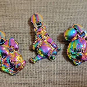 Może przedstawiać: Trzy tęczowe suwaki do zamków błyskawicznych z postaciami z kreskówek. Suwaki są w odcieniach różowego, niebieskiego, zielonego i żółtego. Postaciami są Myszka Miki, Minnie Mouse i Kubuś Puchatek.