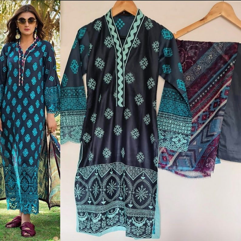 May include: A black and blue patterned dress with a light blue embroidered neckline and trim. The dress has long sleeves and a matching dupatta with a geometric pattern.