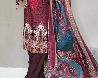 Op de afbeelding: Een marroonkleurige jurk met teal-patroon, lange mouwen en een bijpassende dupatta. De jurk heeft een met pailletten bezette halslijn en een paisley-print.