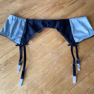 Womens lingerie silver satin & black lace suspender belt, 4 straps, metal clasps, hook and eye close. Sizes uk8 - plus size lingerie uk22.