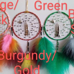 Pu&ograve; includere: Cinque acchiappasogni con cerchi e piume di diversi colori. I cerchi sono arancio/rosa, bordeaux/oro, verde, nero/argento e blu. Ogni acchiappasogni ha un ciondolo a forma di razzo argentato.