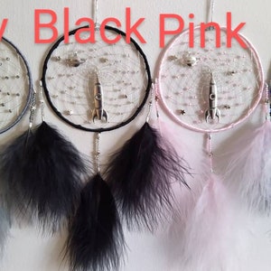 Pu&ograve; includere: Quattro acchiappasogni con cerchi e piume di diversi colori. I cerchi sono grigi, neri, rosa e neri con perline blu. Ogni acchiappasogni ha un ciondolo a razzo argentato.