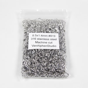 May include: A clear plastic bag filled with numerous small, shiny, silver metal rings. The bag has a white label with black text that reads "8.5x1.4mm #819 316 stainless steel Machine cut VanAlphenStudio."