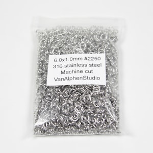 Op de afbeelding: Een zakje zilveren springringen, 6,0x1,0 mm #2250, 316 roestvrij staal, machine gesneden, VanAlphenStudio.