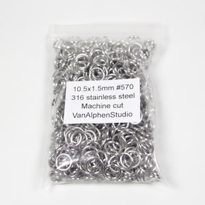 May include: A transparent bag containing a multitude of small, bright, silver metal rings. The rings are closely packed together. A white label on the bag reads "10.5x1.5mm #570 316 stainless steel Machine cut VanAlphenStudio".
