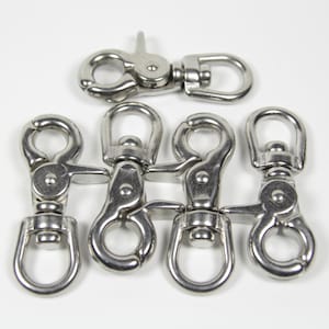 May include: A collection of stainless steel swivel snap hooks. The hooks have a spring-loaded gate and a rotating eye, ideal for various applications. The image shows six hooks, with one hook positioned separately above the others.